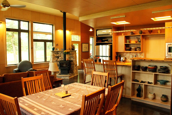 View of dining room and kitchen with masonry stove.